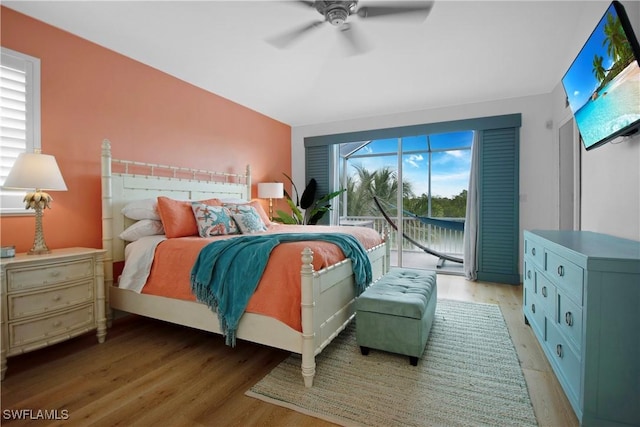 bedroom with ceiling fan, wood-type flooring, access to outside, and multiple windows