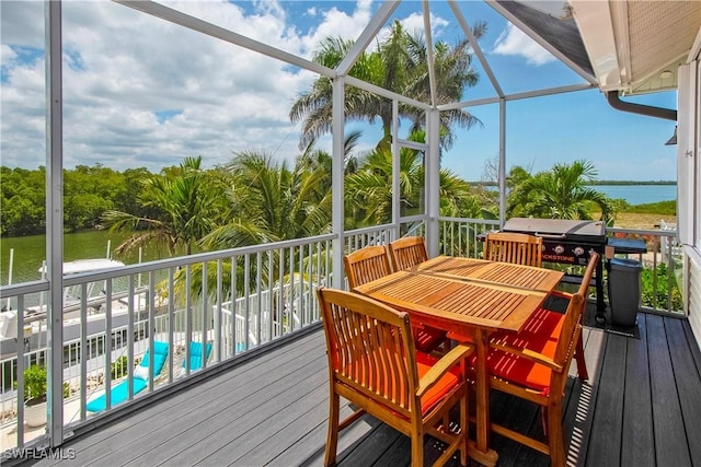 deck with glass enclosure, a water view, and a pool