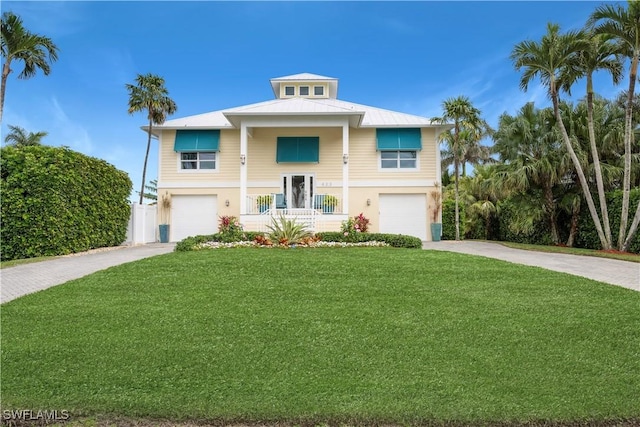 view of front facade featuring a front yard, covered porch, and a garage