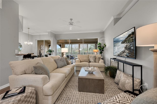 living room featuring ceiling fan with notable chandelier, ornamental molding, and light hardwood / wood-style flooring