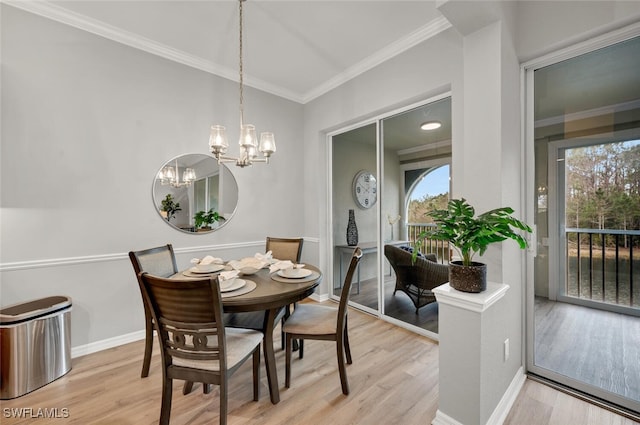 dining room with a chandelier, plenty of natural light, ornamental molding, and light hardwood / wood-style flooring