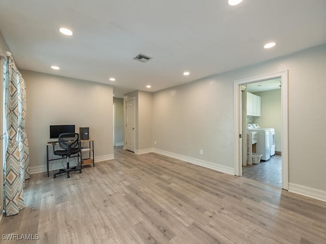 home office with washer / clothes dryer and light hardwood / wood-style flooring