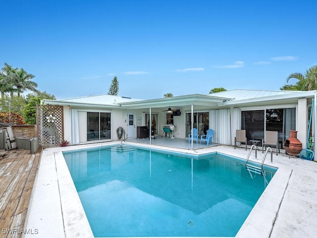 view of swimming pool featuring ceiling fan and a patio