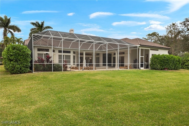 rear view of house featuring a lanai, a yard, and a chimney