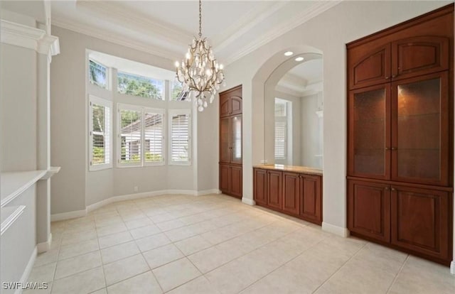 unfurnished dining area with light tile patterned flooring, ornamental molding, a notable chandelier, and a tray ceiling