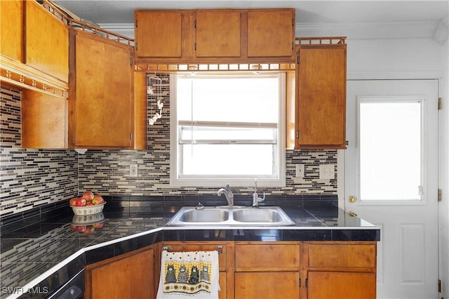 kitchen featuring sink, ornamental molding, backsplash, and plenty of natural light