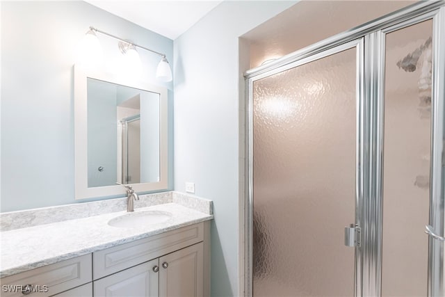 bathroom featuring vanity and a shower with shower door