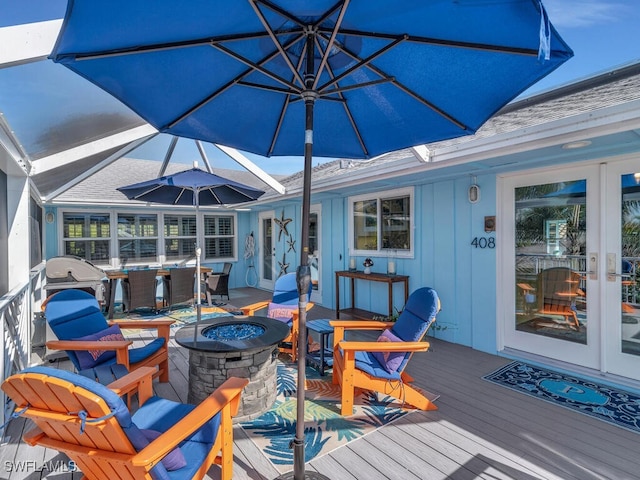 deck with an outdoor fire pit and a grill