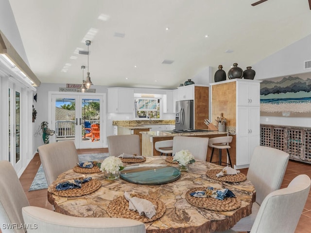 tiled dining area featuring vaulted ceiling, french doors, and sink