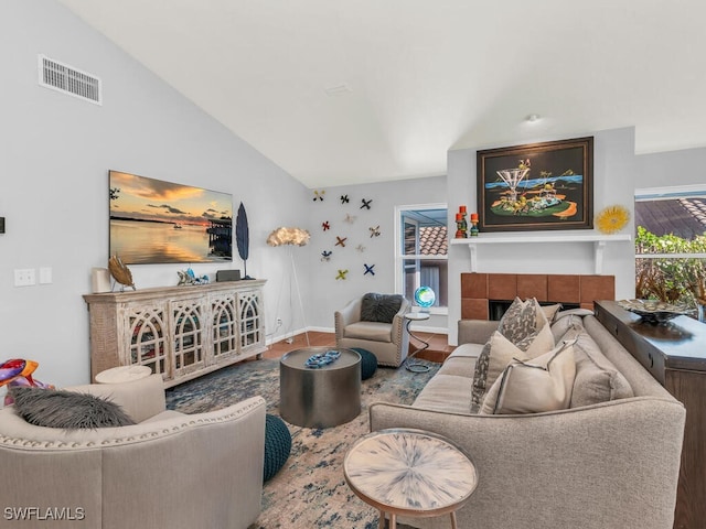 living room with vaulted ceiling and a tile fireplace