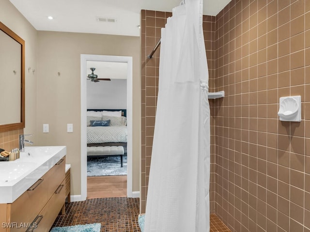 bathroom featuring ceiling fan, tile patterned floors, walk in shower, and vanity