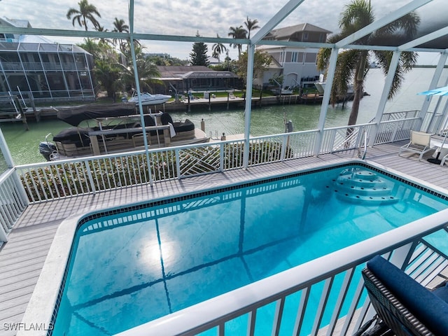 view of pool with a lanai and a water view