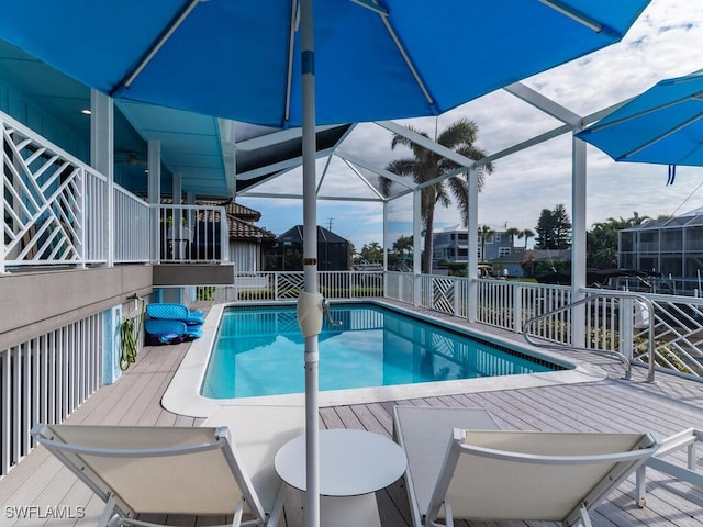 view of swimming pool featuring glass enclosure and a deck