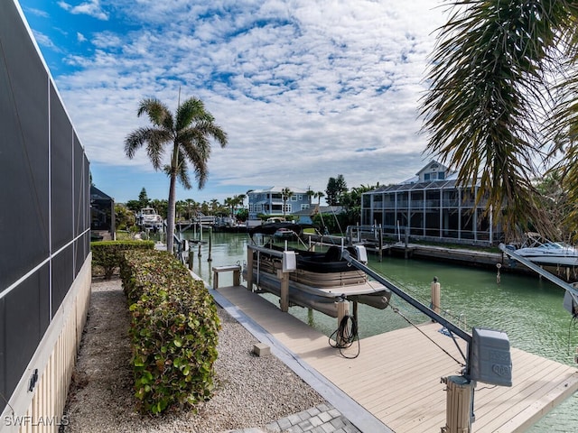 dock area with a lanai and a water view