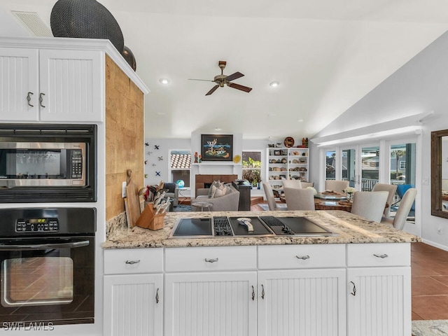 kitchen with ceiling fan, white cabinets, black appliances, and vaulted ceiling