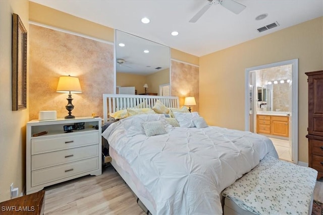 bedroom with ensuite bathroom, ceiling fan, and light wood-type flooring