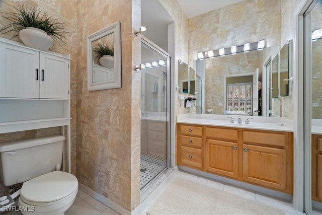 bathroom with toilet, a shower with door, tile patterned flooring, and vanity