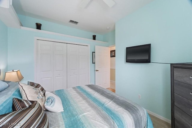 carpeted bedroom with ceiling fan and a closet