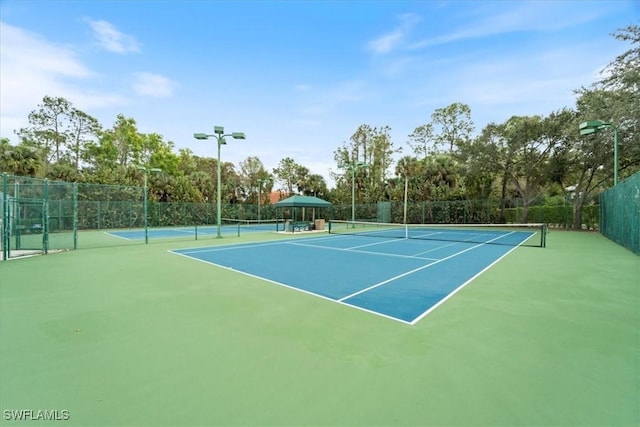 view of tennis court with basketball hoop