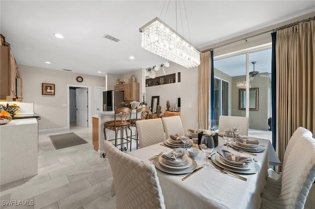 dining area featuring ceiling fan with notable chandelier