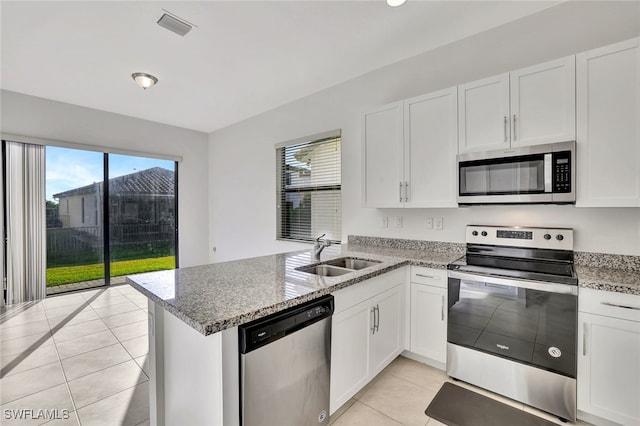 kitchen featuring sink, stainless steel appliances, white cabinetry, and light tile patterned flooring