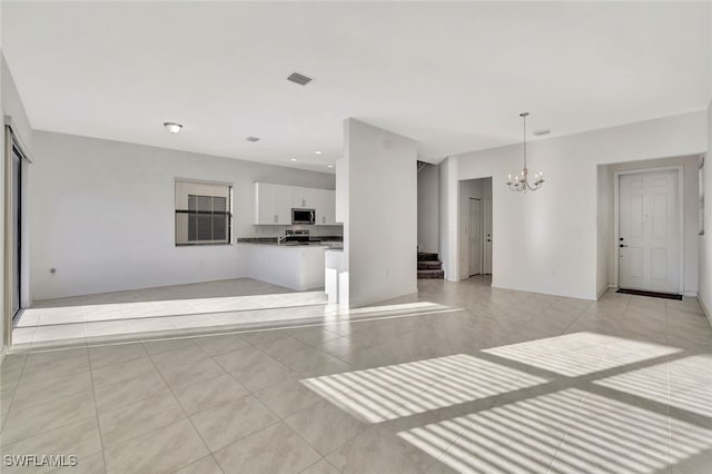 unfurnished living room featuring a notable chandelier