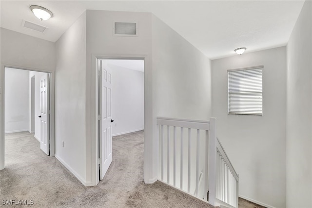 hall with light colored carpet