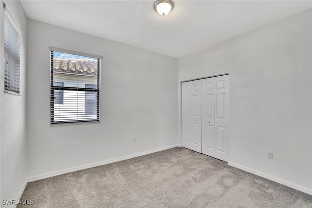 unfurnished bedroom with a closet and light carpet