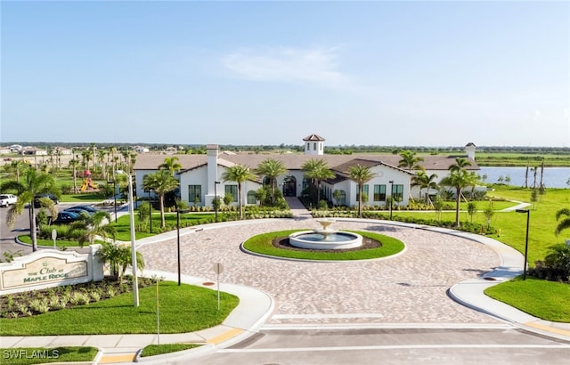 view of home's community with a lawn and a water view