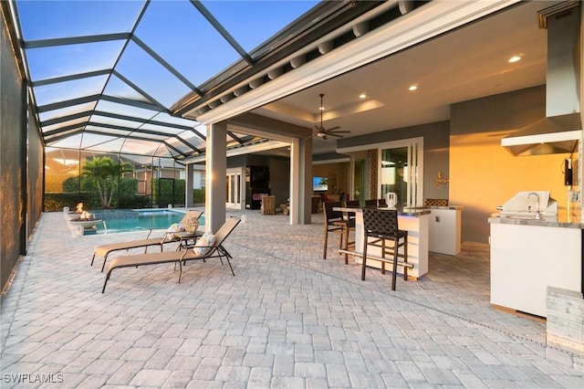 view of swimming pool featuring an outdoor bar, ceiling fan, a patio, a grill, and exterior kitchen