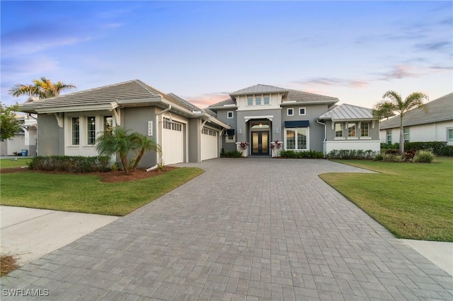 view of front facade featuring a garage and a yard