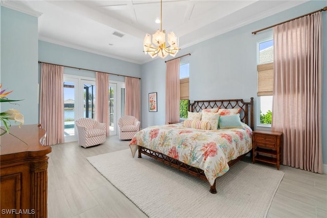 bedroom with a water view, access to exterior, multiple windows, and a notable chandelier