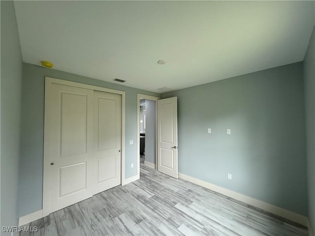 unfurnished bedroom featuring a closet and light wood-type flooring