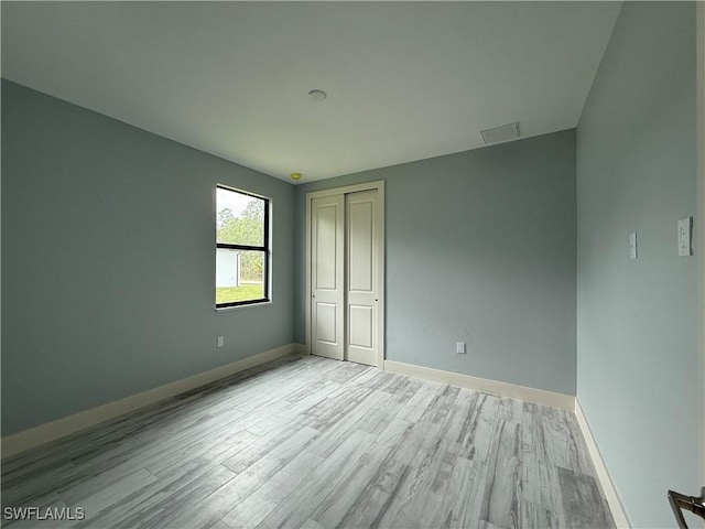 unfurnished bedroom featuring a closet and light hardwood / wood-style floors