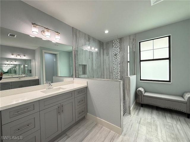 bathroom with vanity and tiled shower