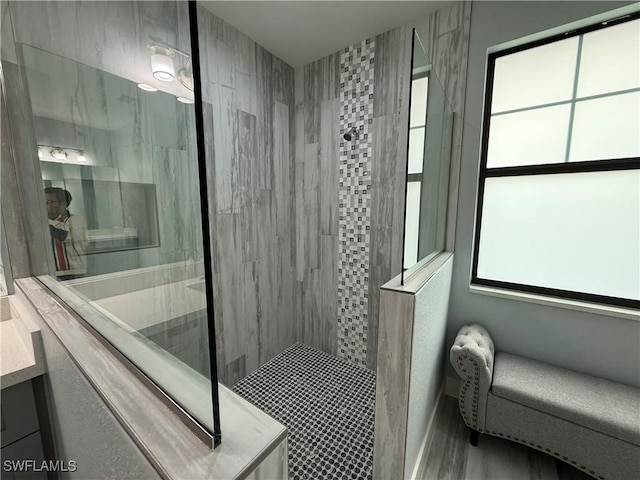 bathroom featuring tiled shower and vanity