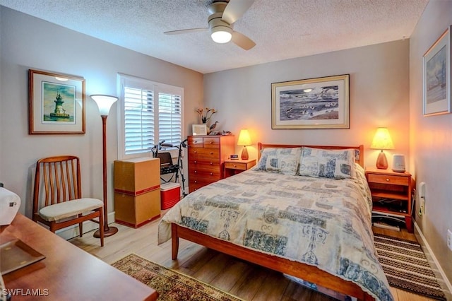 bedroom featuring ceiling fan, light hardwood / wood-style flooring, and a textured ceiling