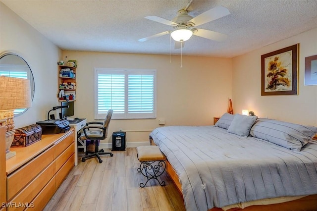 bedroom featuring ceiling fan, a textured ceiling, and light wood-type flooring