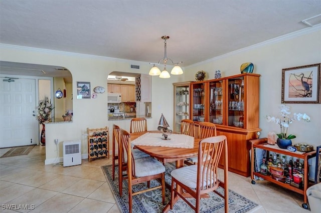 tiled dining space featuring crown molding, sink, and a notable chandelier