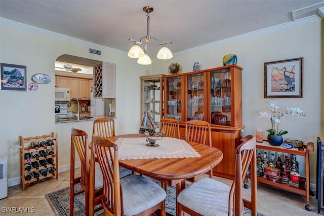 tiled dining room featuring crown molding and ceiling fan