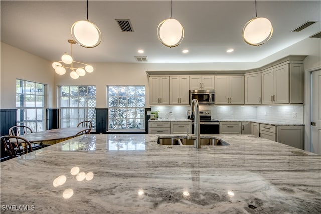 kitchen with tasteful backsplash, pendant lighting, and appliances with stainless steel finishes