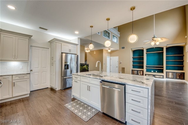 kitchen with ceiling fan, appliances with stainless steel finishes, sink, pendant lighting, and an island with sink