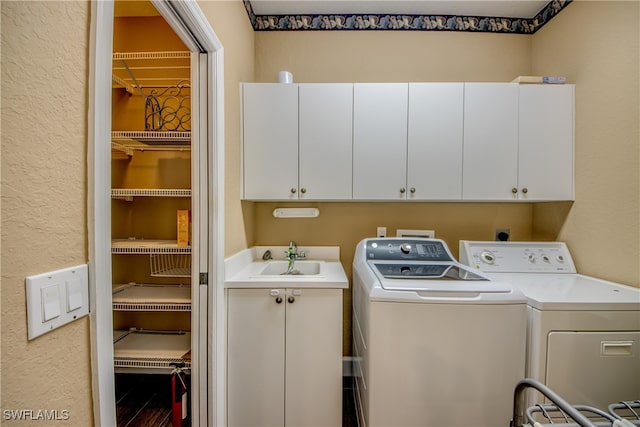 washroom with cabinets, separate washer and dryer, and sink