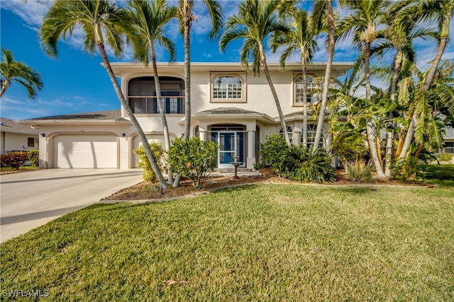 view of front of house with a front yard, driveway, and stucco siding