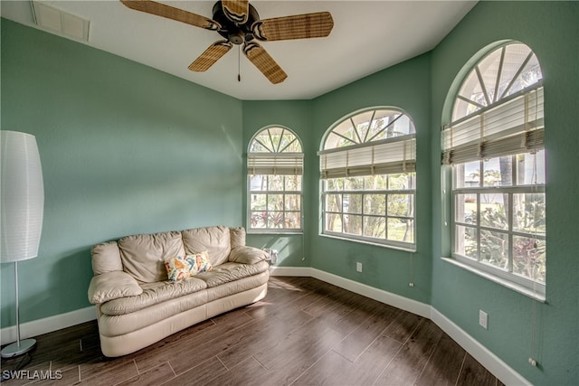 living area with ceiling fan and dark hardwood / wood-style flooring