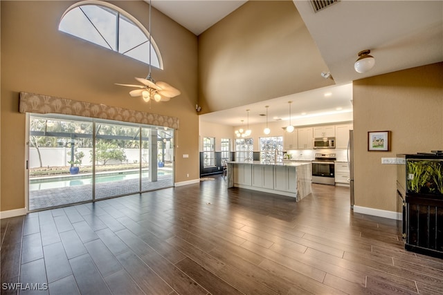 unfurnished living room with a high ceiling and ceiling fan