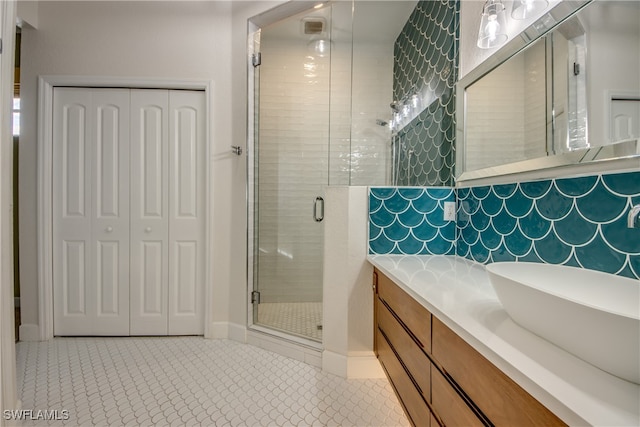 bathroom featuring a shower with shower door, tile patterned floors, and vanity