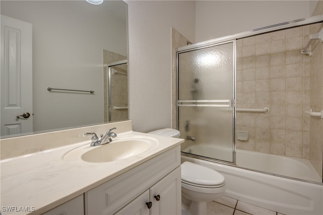 full bathroom with vanity, toilet, bath / shower combo with glass door, and tile patterned flooring