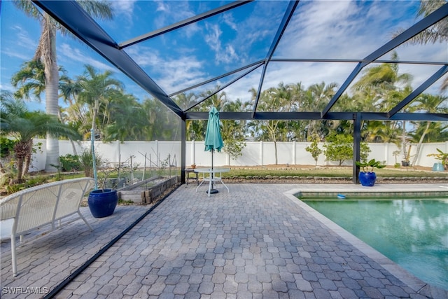 view of swimming pool with glass enclosure and a patio