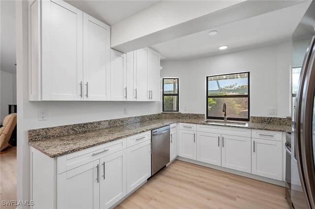 kitchen featuring appliances with stainless steel finishes, white cabinetry, and sink